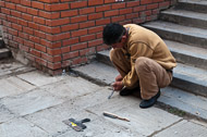A workman scraping grooves in the concrete walk leading to the monastery _DSC0709.jpg